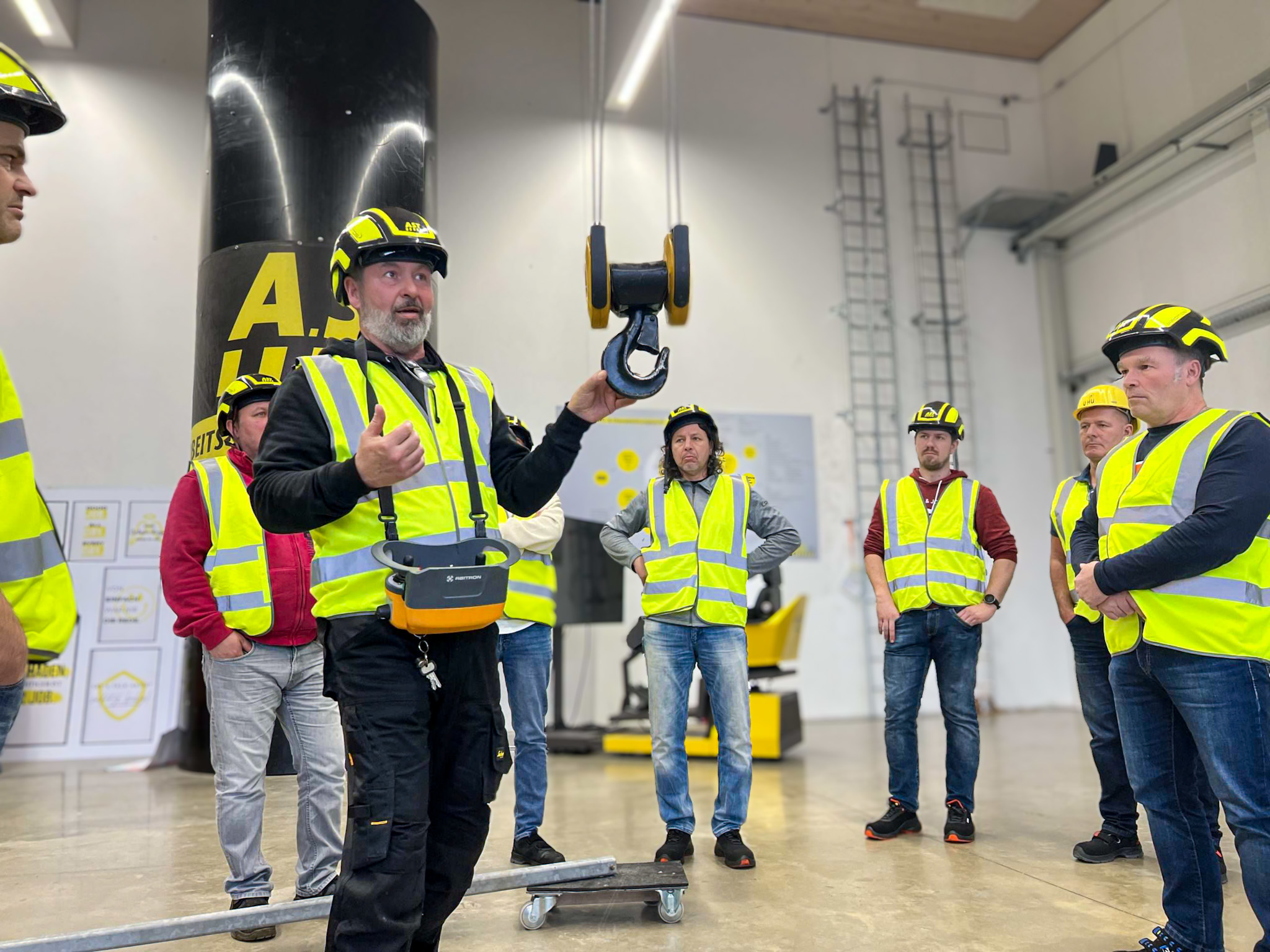 AST-Trainer erklärt angehenden Kranführer-Ausbildern einen Kranhaken.