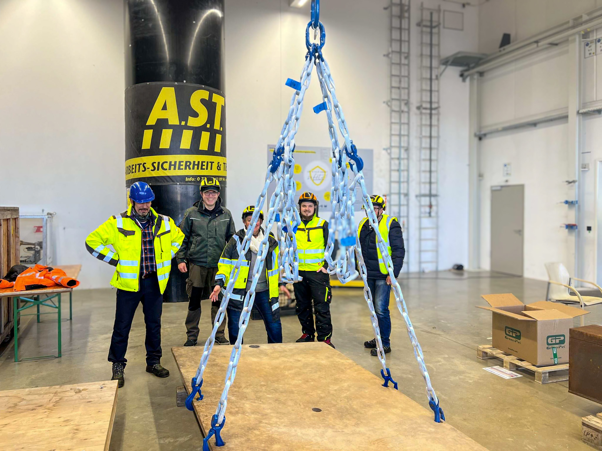 AST-Schulungsgruppe begutachtet einen praktischen Aufbau aus Anschlagmitteln.